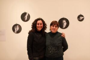 Esther Naval y su madre posan frente a “Universos”, fotos impresas en tela sobre bastidores, zurcidas por Mª Cruz, la madre de la artista.